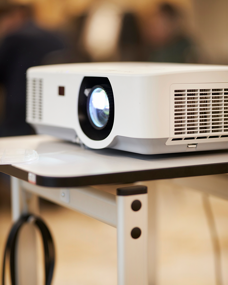 Imagebild Tagung: Beamer steht auf einem Tischchen